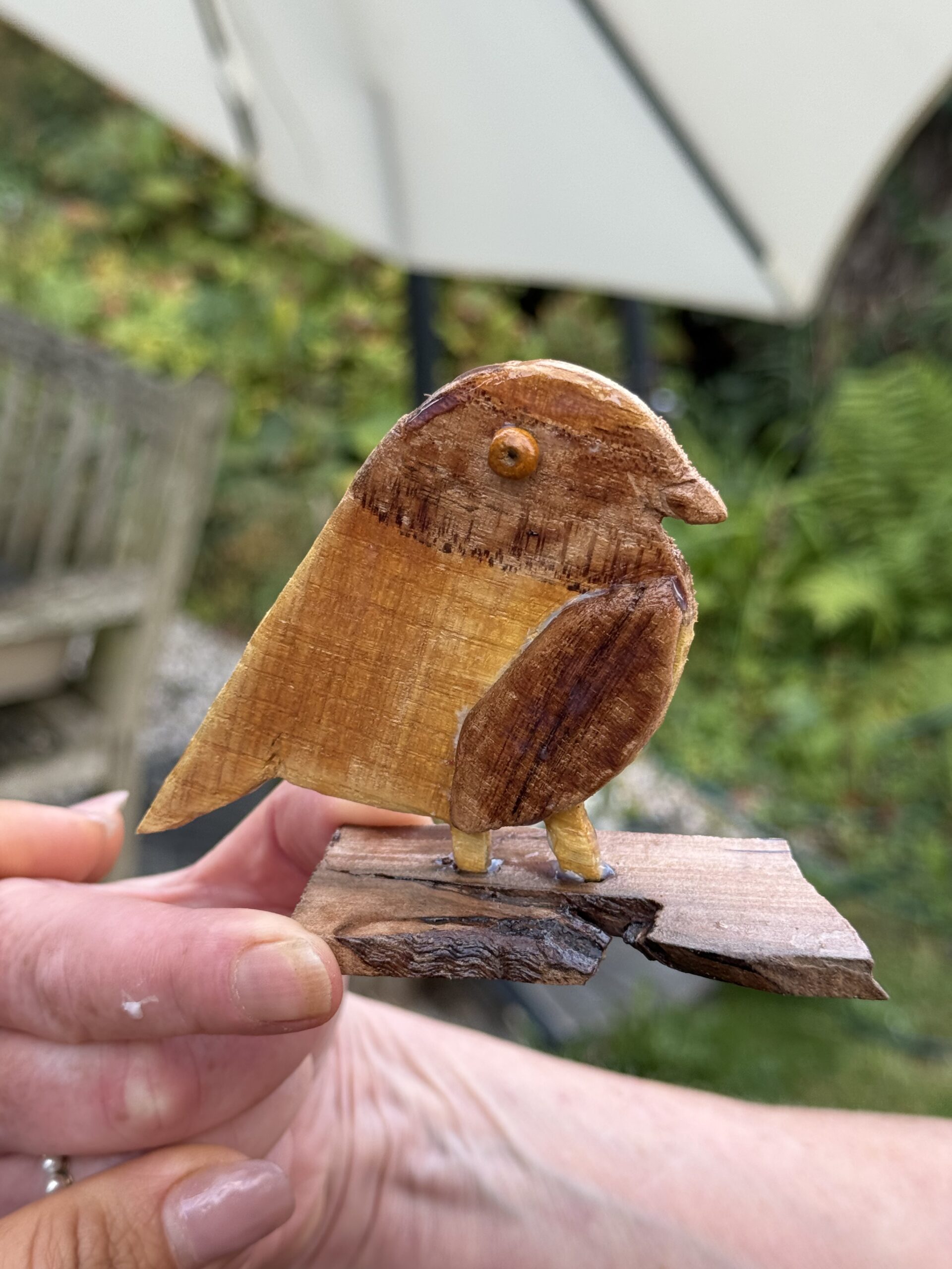 Galerij Hand-carved wooden bird figure mounted on a driftwood stand