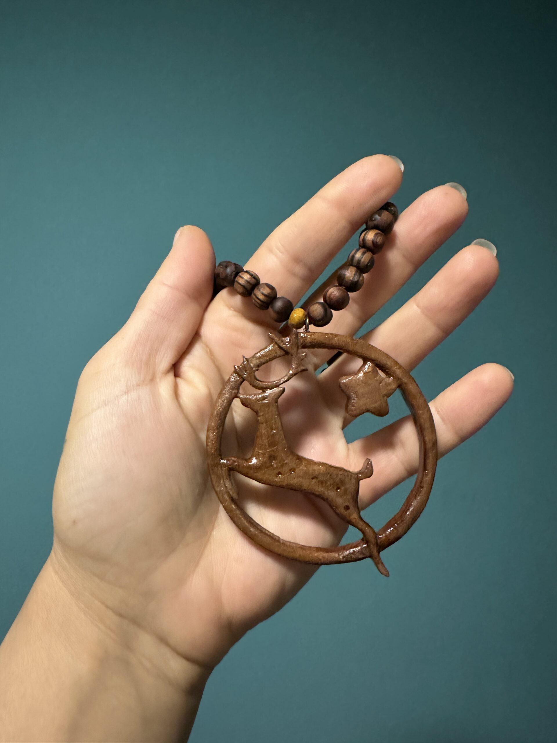 Galerij Wooden pendant necklace with a leaping deer charm and star charm