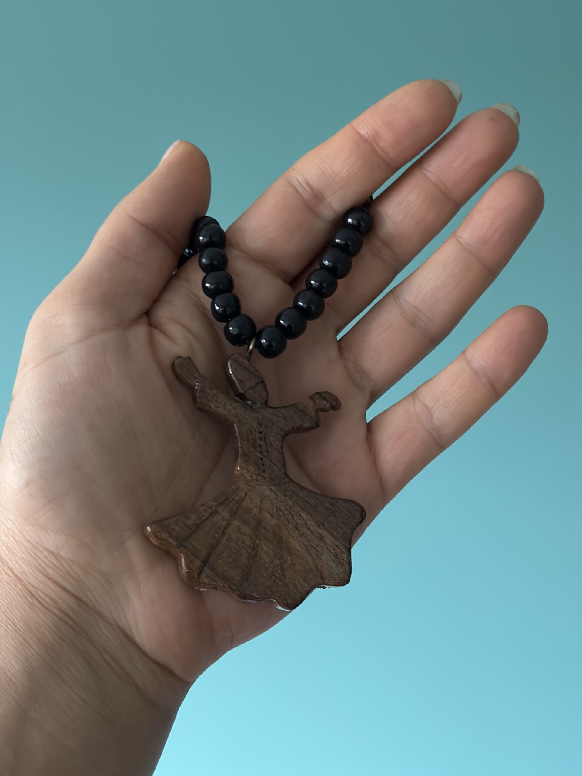 Galerij Small wooden whirling dervish pendant on a beaded cord