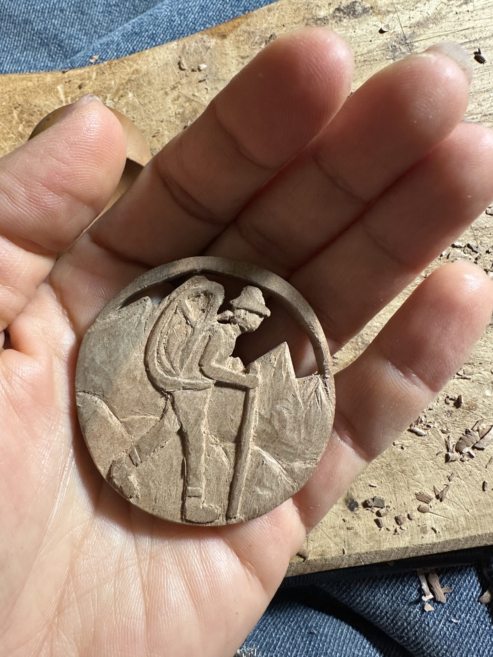 Galerij Round wooden medallion carved with a hiker figure