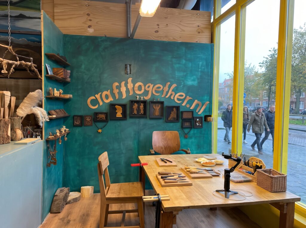 Book a workshop The Craft Together atelier at MIAW Gallery in The Hague: carving tools on a wooden table in front of a teal wall with the crafttogether.nl sign